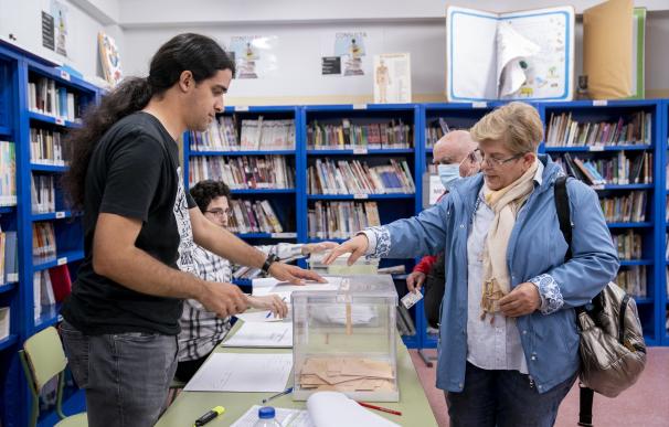 Una mujer mete su voto en una urna en un colegio electoral, a 28 de mayo de 2023