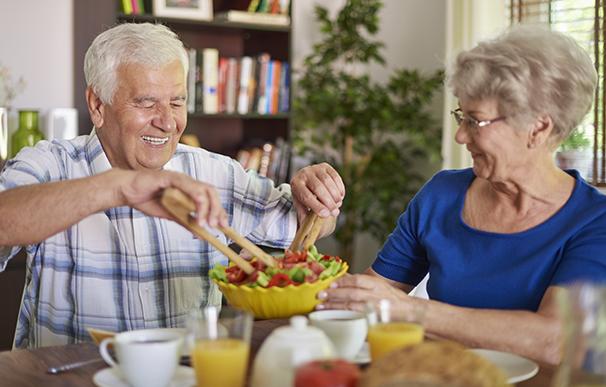 Una pareja de jubilados disfruta de una comida saludable en la mesa
