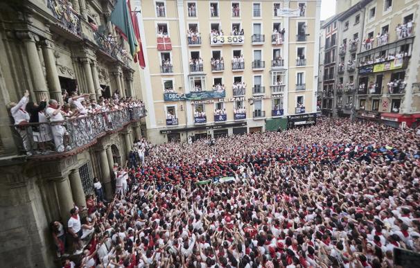 Vista general de la Plaza del Ayuntamiento con decenas de personas que alzan el típico pañuelo rojo de San Fermín
