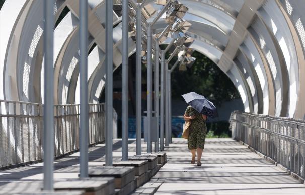 Una mujer se cubre del sol con un paraguas en Madrid Río, a 11 de julio de 2023, en Madrid