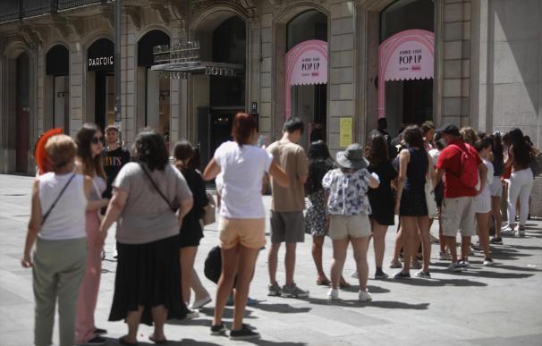 Varias personas esperan la cola para entrar a la tienda de Shein, en Barcelona.