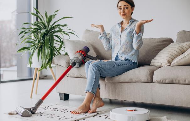 Woman sitting on sofa and choosing vacuum cleaner