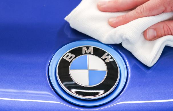 Un empleado de BMW saca brillo al logo de la marca.