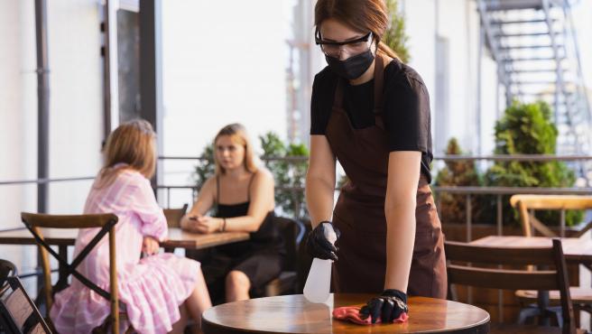 Una de las medidas contra la COVID-19 consiste en la desinfección y limpieza de las mesas y las sillas de los restaurantes en cada servicio.