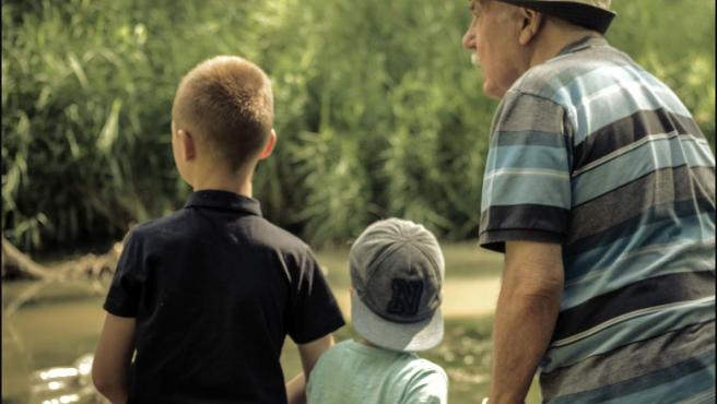 Fotografía de un pensionista con sus dos nietos.