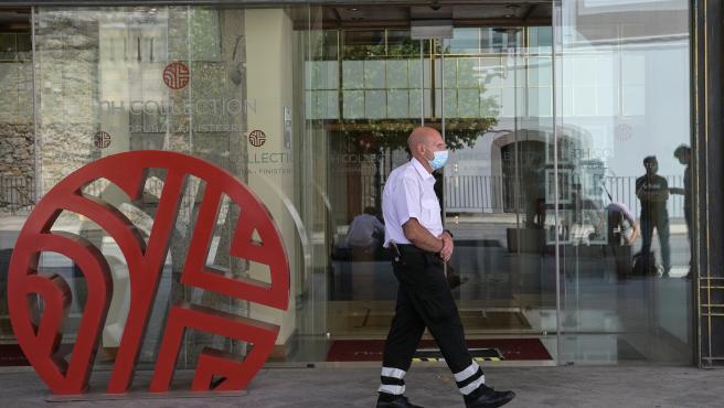 Un trabajador de seguridad camina cerca de la puerta del hotel NH Finisterre de A Coruña donde los jugadores del CF Fuenlabrada permanecen confinados en él tras haber dado positivo en coronavirus varios de sus miembros.