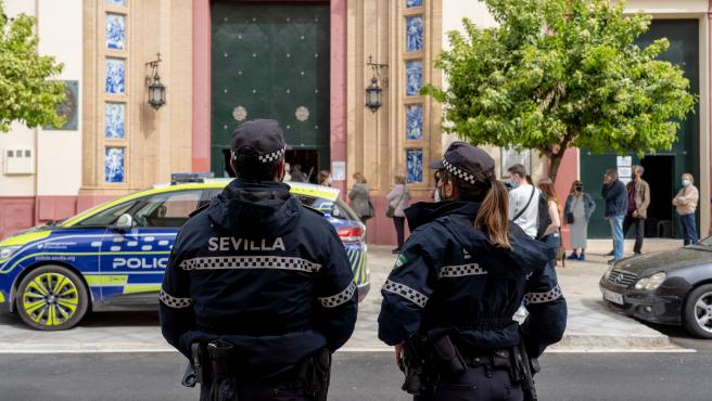 Dos policías locales pendientes de  la cola en la Basílica del Stmo. Cristo de la Expiración de Sevilla.