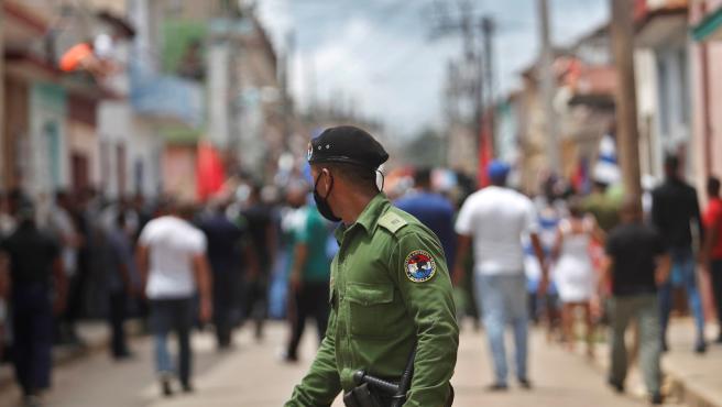 Un integrante de las brigadas especiales observa a los manifestantes tras la protesta contra el Gobierno de Cuba por las calles del pueblo San Antonio de los Baños (Cuba).