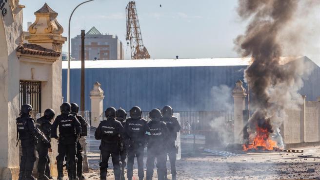 Un grupo de Policías antidisturbios ante los trabajadores del sector del metal que se manifiestan ese martes a la puerta de la factoría de Navantia de Cádiz